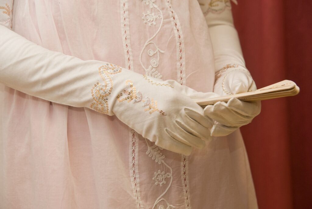 the great war and beyond - edwardian woman holding a fan  wearing white dress gloves