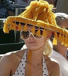 post war times - woman in halter top wearing large sunglasses and lampshade tassled hat