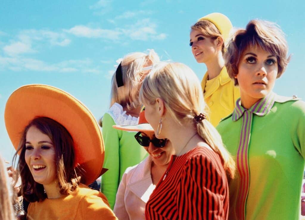 swinging 60's & 70's - group of girls in mod fashion and bright tangerine colours