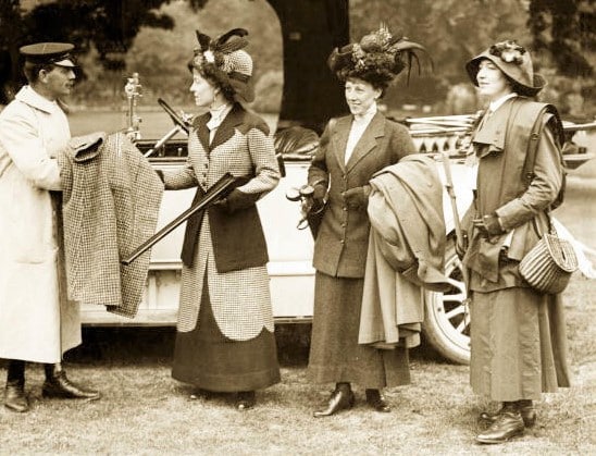 the victorian era - ladies passing their coats to a chauffeur while they prepare to do shooting