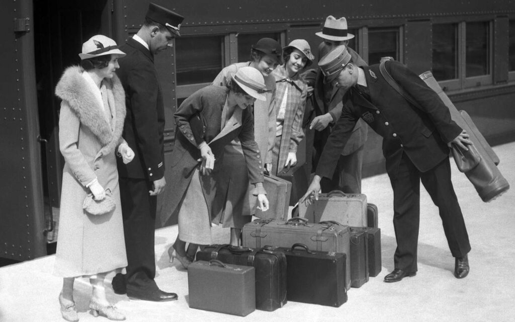 suitcases were invented - a group of people around 1940 examining different suitcases