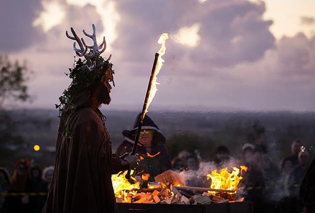 the origins of halloween - celts in costume at a bonfire ceremony at dusk