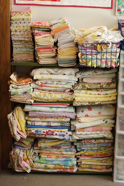 the beauty and appeal of vintage textiles - shelves loaded with folded fabric pieces of all styles and colours