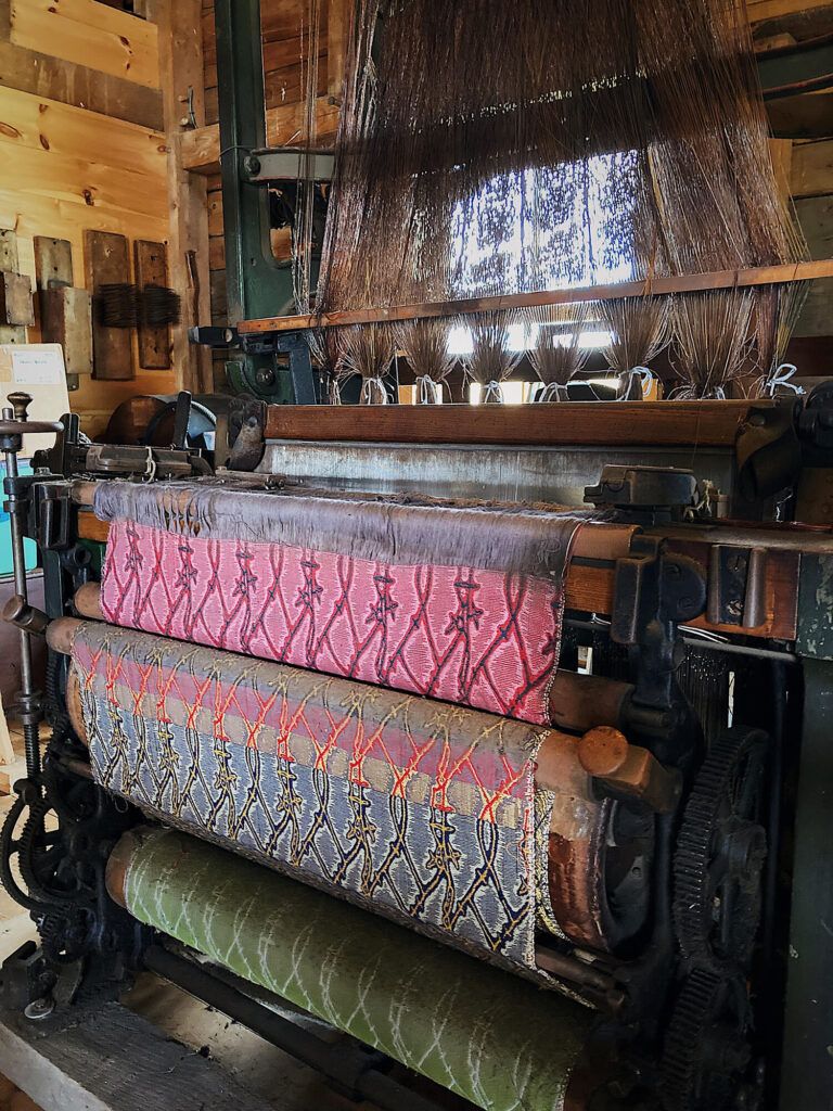 the beauty and appeal of vintage textiles - artisan craftsmanship at marshfield school of weaving depicting a loom with bright patterns