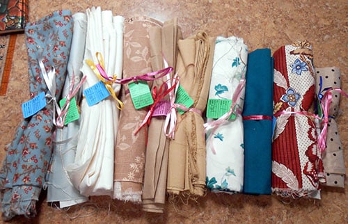 the beauty and appeal of vintage textiles - fabric samples in a row bound by ribbon