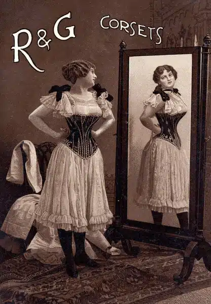 choosing the right corset for your vintage style - old corset advertisement of a woman admiring her corset in a mirror