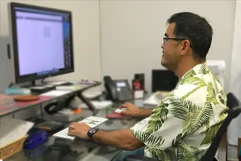 all things bold and flouro - hawaiian man in office wearing hawaiian shirt.