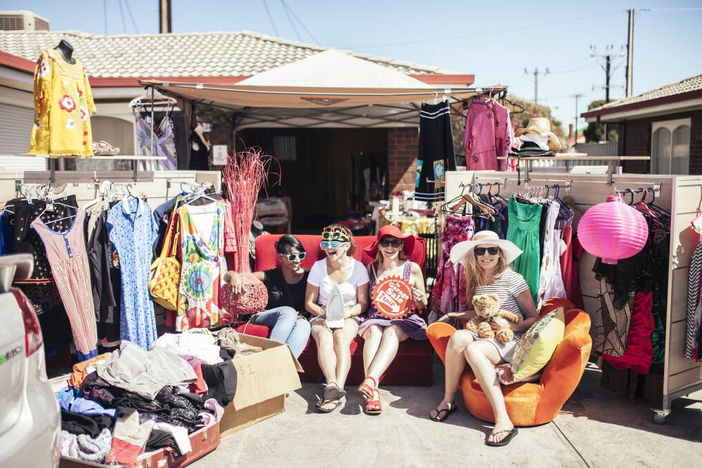 where to find quality vintage textiles - local garage  sale with clothing racks and overflowing boxes of bargains