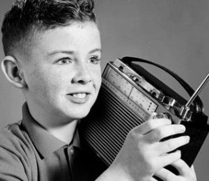 understanding big band's popularity - a young boy holding a transistor radio listening to the big band sound