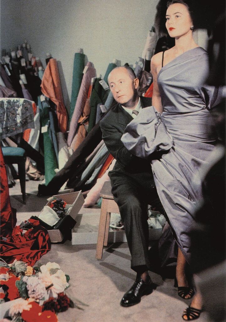 when the swing style really took off - designer christian dior fitting a model with a dress designed