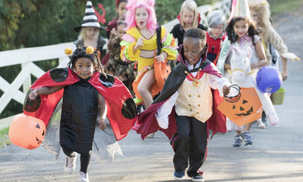 pop culture influence - mix culture children running with treat bags in costume