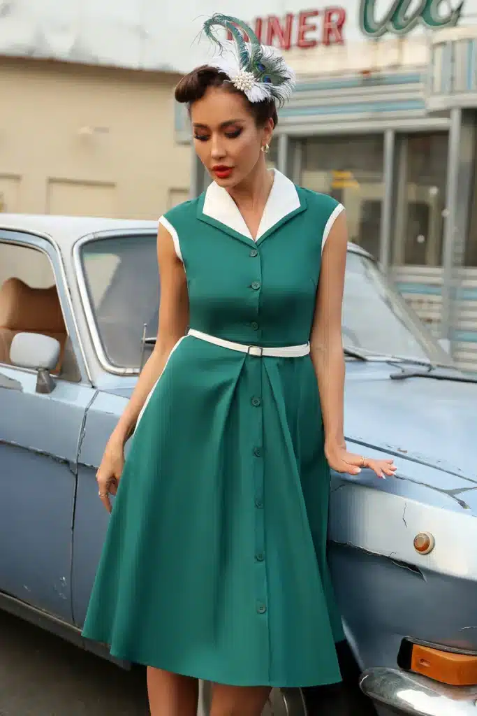 big band era's influence on fashion - lady standing next to a vintage car in a 1950's cap sleeve dress with collar