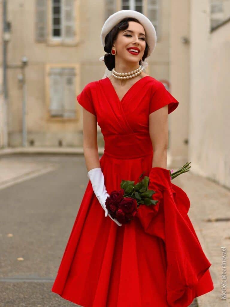 1940's/1950's era - woman in a red dress outside a building wearing pearls and accessories