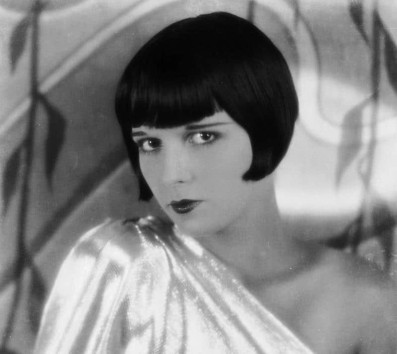 gatsby's role in women's flapper style - woman with styled bobbed hair wearing one shouldered satin dress