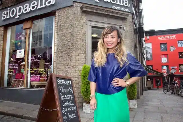 finding second hand gems for st.patrick's day - woman standing outside 2nd hand thrift shop ella's superstore, wearing retro clothing