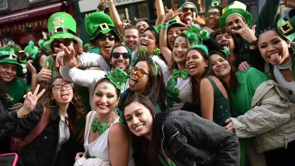 the significance of wearing green on st.pats day - people laughing and cheering wearing green accessories