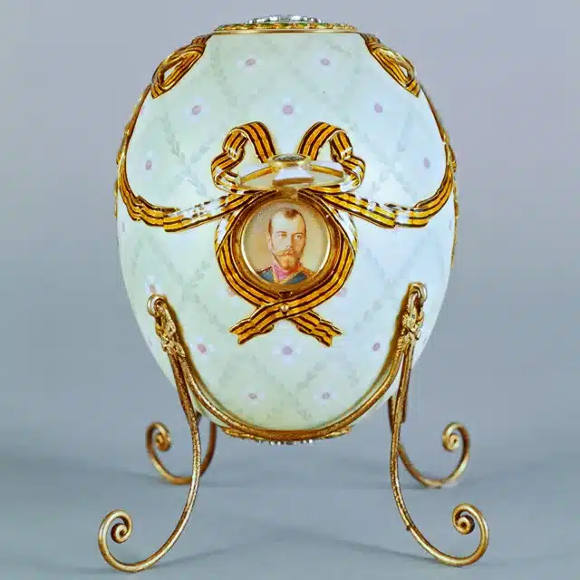 the symbolic grandeur of faberge eggs - order of st. george egg circa 1916 - white egg embellished with gold trim and the tsar's face on the front