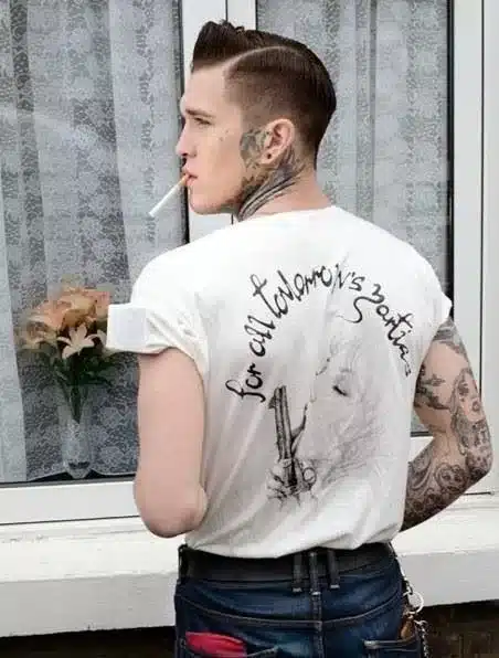 reviewing the essence of rockabilly style for men - mans back in white t.shirt and jeans with ciggy in mouth and tattoos