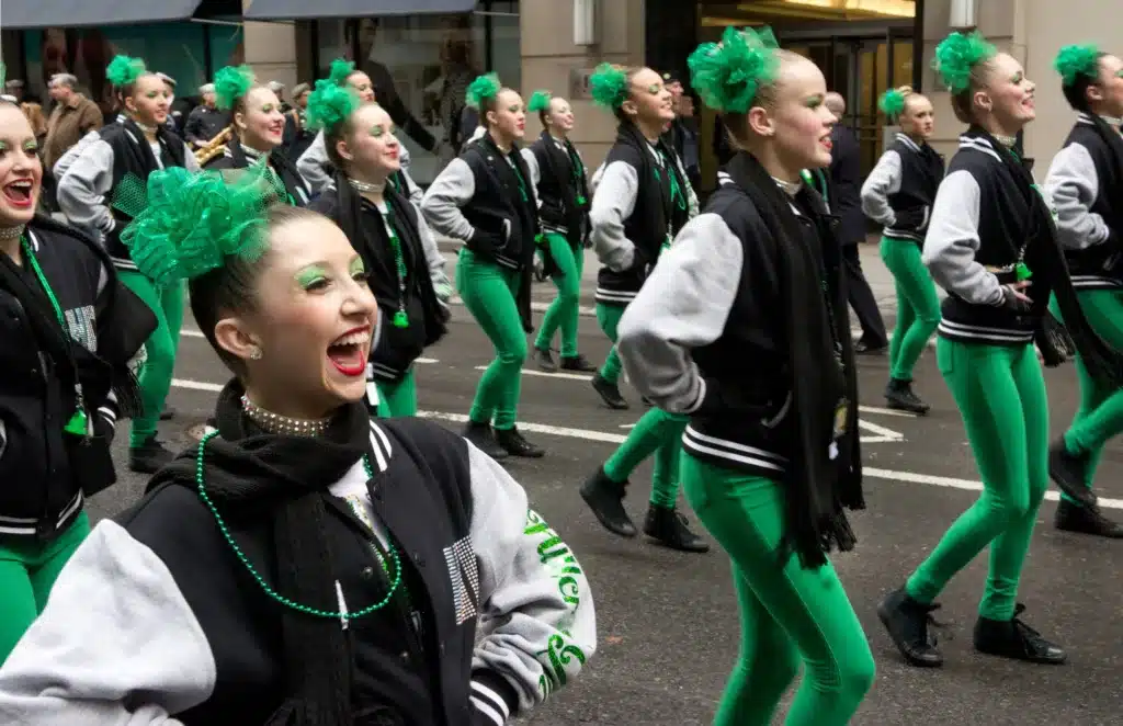how attire on st. patricks day speaks to cultural pride - a group of all girl dancers marching in bomber jackets and green pants