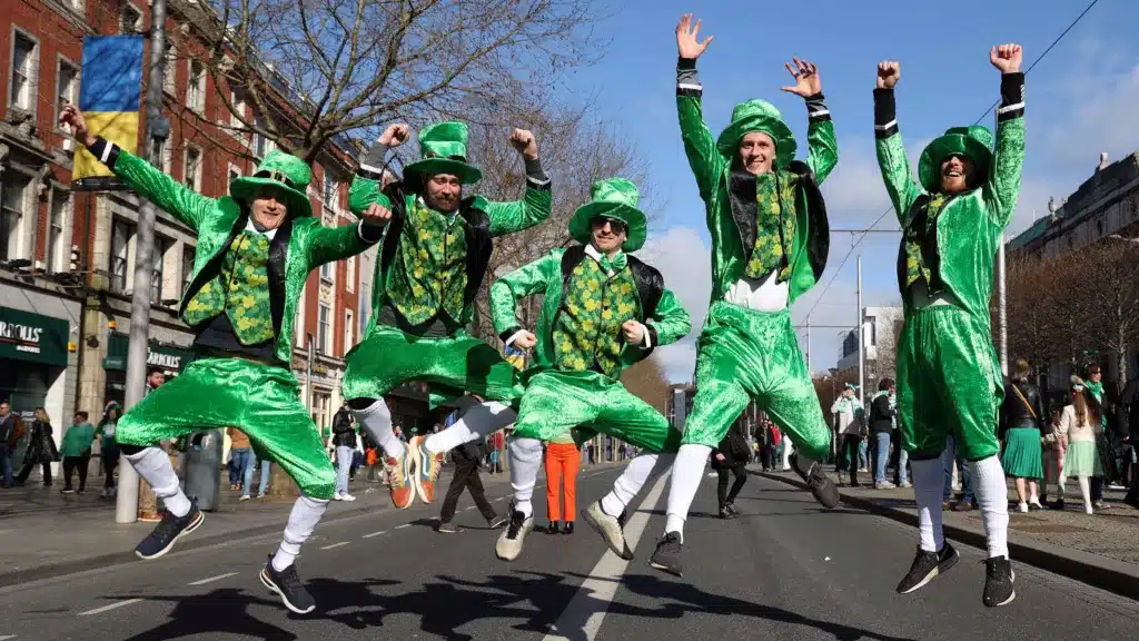parades and festivals - modern day men dressed as lepechauns leaping in the air
