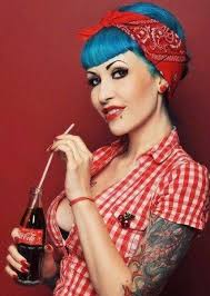 key elements of rockabilly fashion, bandanas and headscarves - woman wearing checked shirt, bandana and red accessories sporting tattoos and blue coloured hair