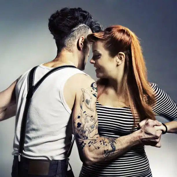 key elements of rockabilly fashion, band merchandise - young couple practicing dancing in casual tops