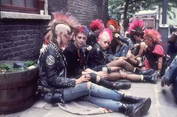 how to spot authentic vintage clothing, popular styles and subcultures - groupies of the sex pistols meeting together sporting wild hair, piercings and spiked leathers