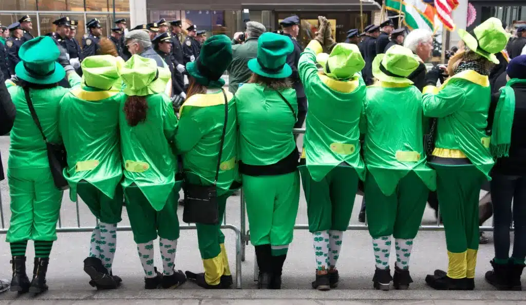parades and festivals - a group of irish people watching a parade in leprechaun costumes
