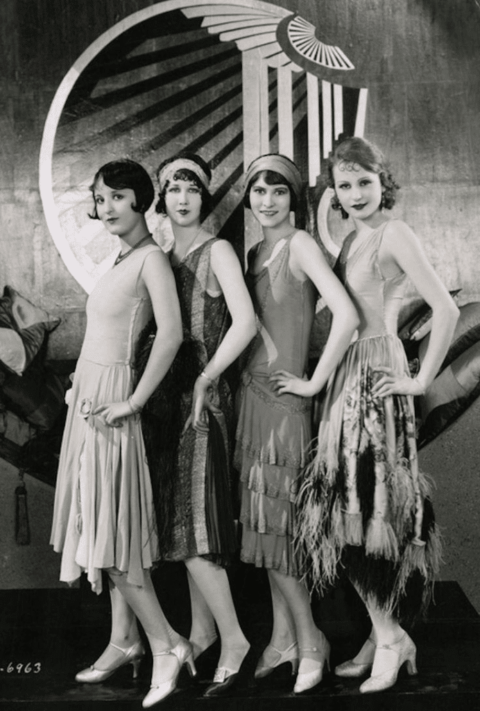 key elements of 1920's flapper girl fashion - 4 women in hankerchief style flapper dresses