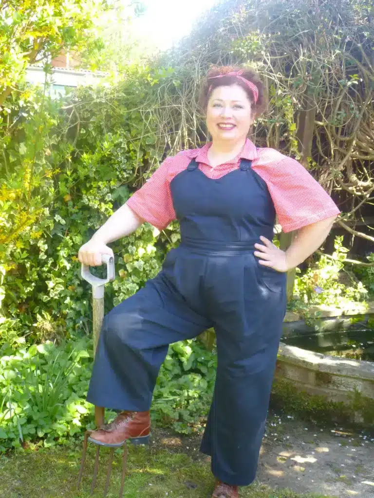 vintage work-wear essentials - from practicality to empowerment, woman in navy overalls and pink shirt doing gardening