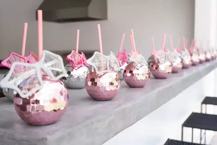 tips on organising a captivating themed party - rock star themed decor drinking cups in pink and white sequins
