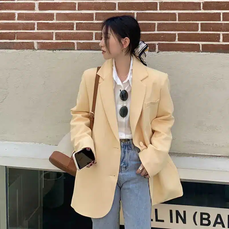 the tailored blazer - a versatile staple, woman wearing oversized yellow blazer with denim jeans