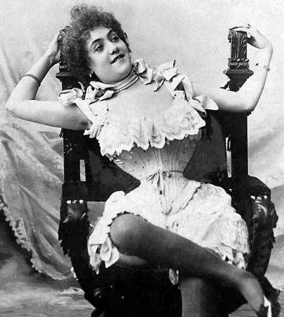 Victorian woman in her underwear sitting on a chair with extremely tight corset