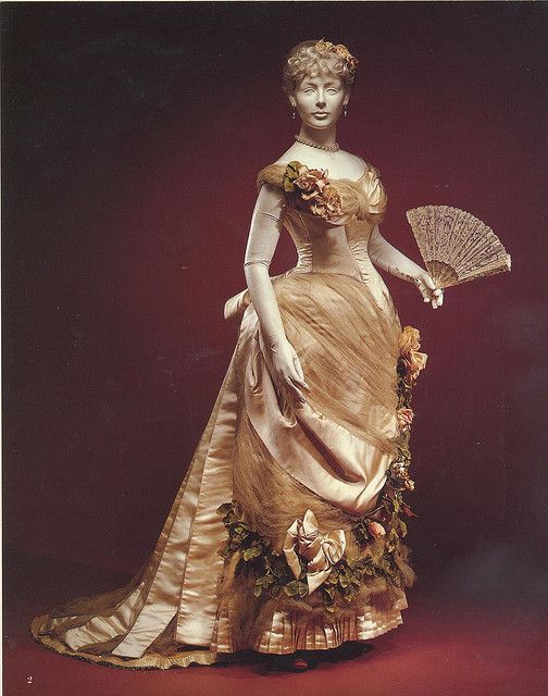 Elaborate Victorian evening gown with embellishments on a model