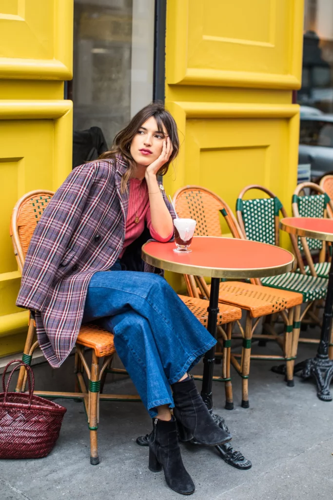 jeanne damas in a tweed coat jeans and black suede boots