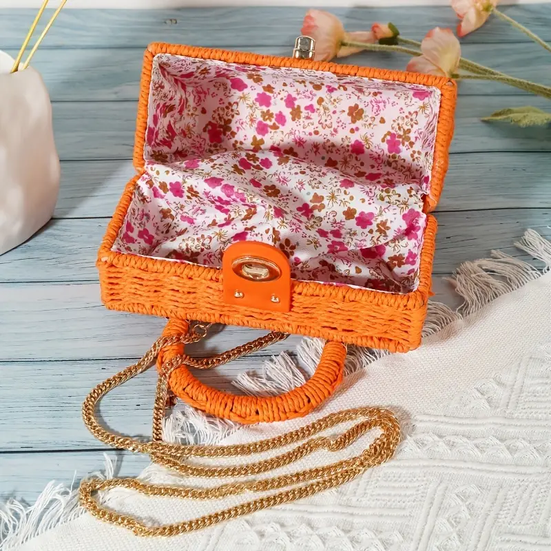 Bright orange wicker bag with chain detail and floral insert