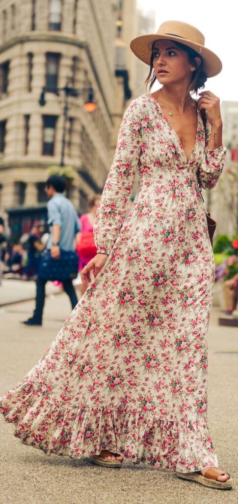 lady walking in a euro street wearing long floral dress with hat