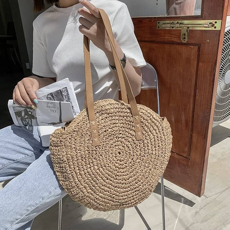 lady holding oval shaped straw shoulder bag