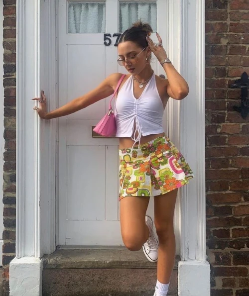 lady wearing a modern white top with floral mini skirt and sneakers