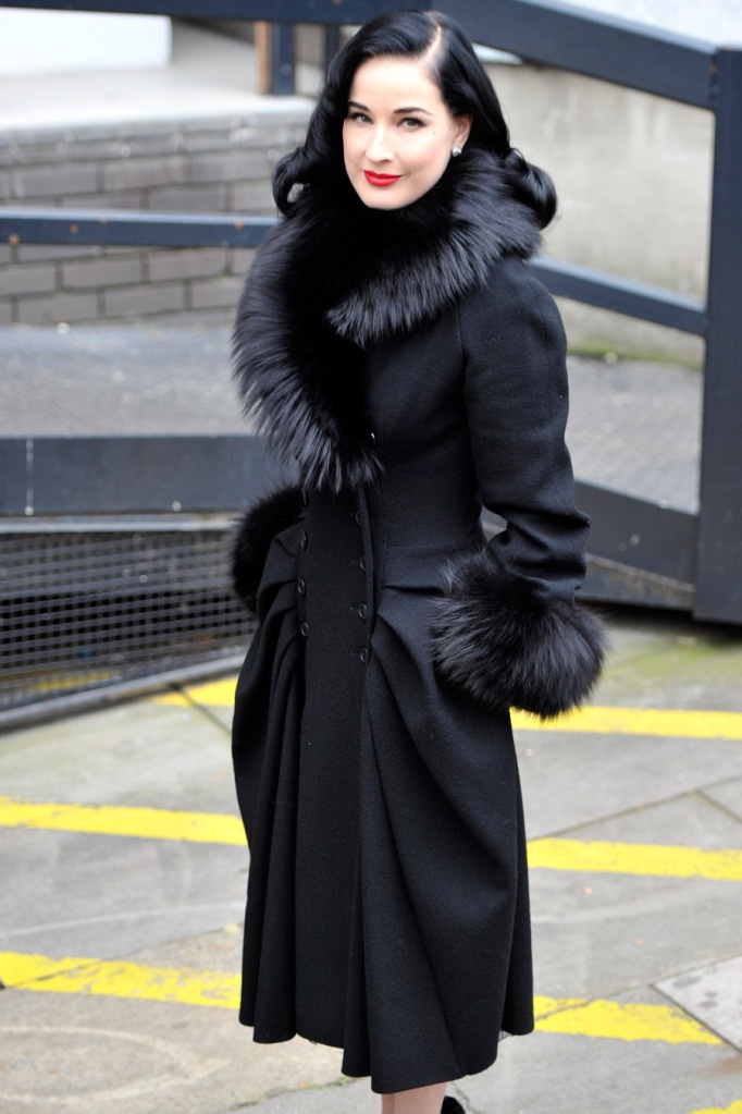 dita von tesse in a black wool fitted coat and fur collar and sleeves