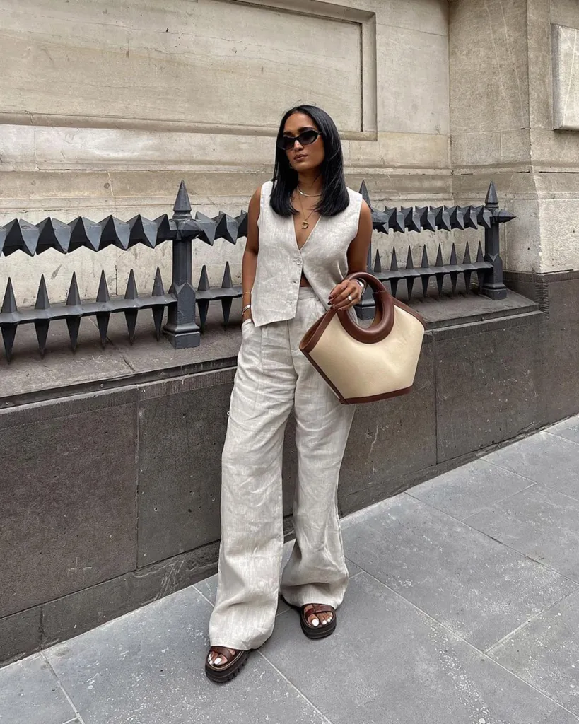 lady in a linen sleevless pant suit with vintage style tote bag