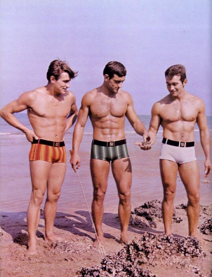 3 fit 1960's guys on the beach wearing tight striped bathers with belt desin