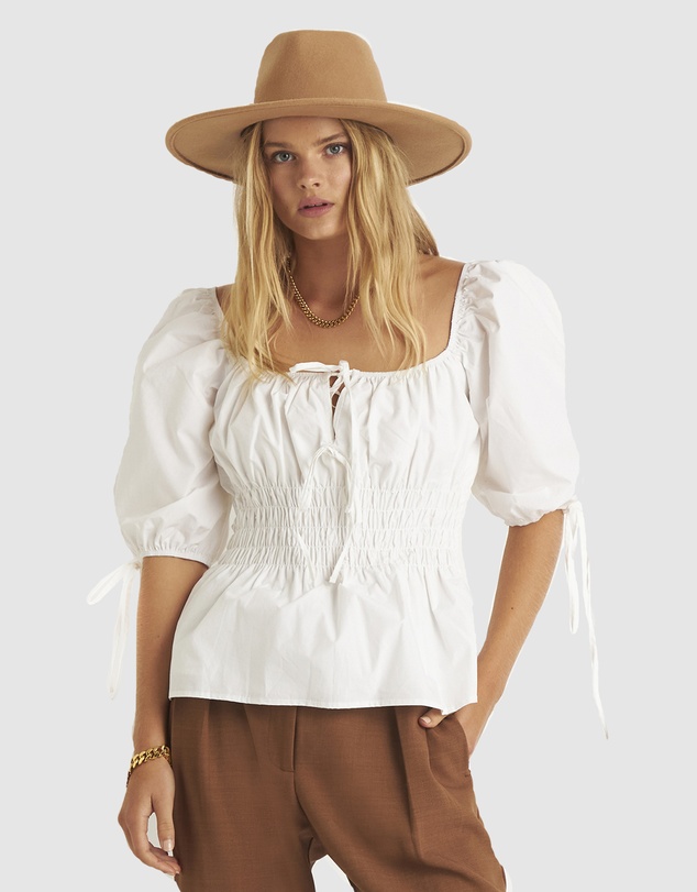 lady wearing peasant white blouse and wide brim felt hat