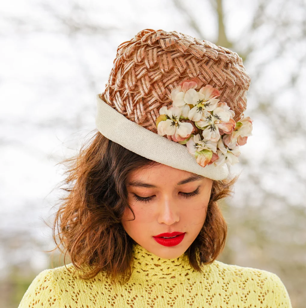 Lady wearing a tall straw hat fabric trim and flower adornments