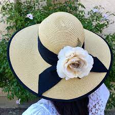 lady in wide brimmed straw hat with flower and scalf adornment