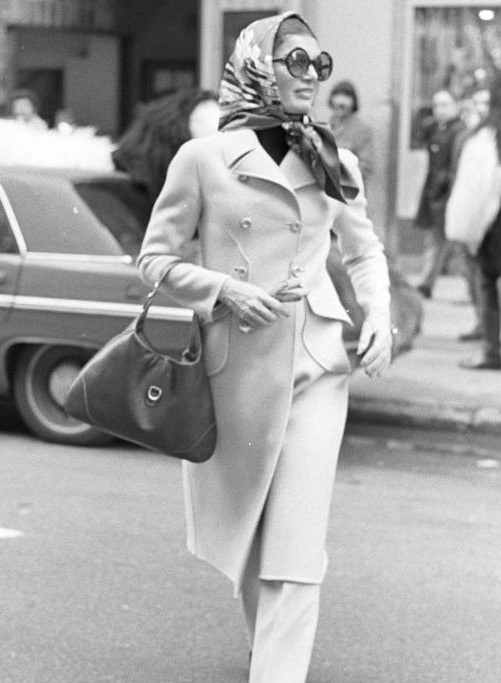 jackie kennedy in a full length coat trousers and head scalf