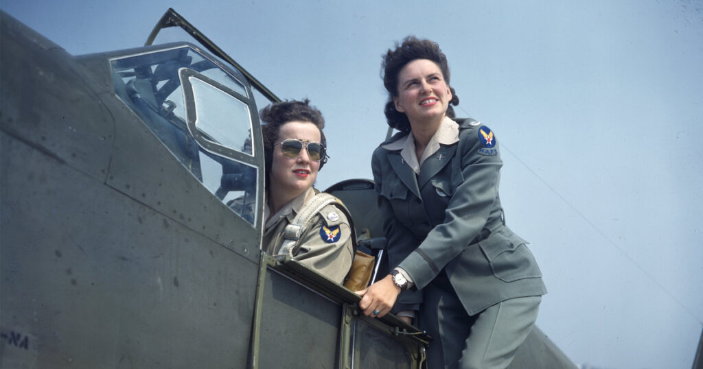 2 women on a US fighter Jet in military uniform attire