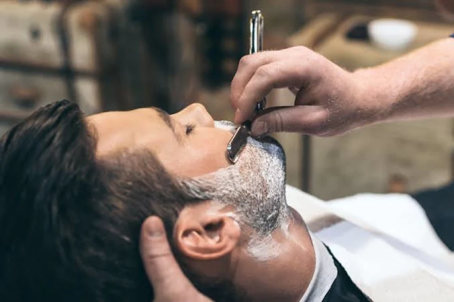 Man having a straight razor shave at a barbers