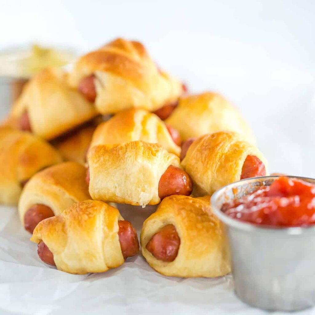 Mini Frankfurts covered in pastry with a relish on the side