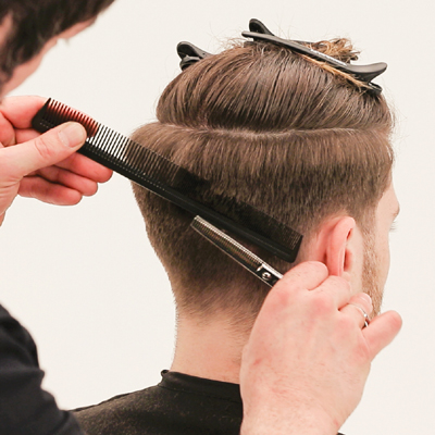 Man getting a scissor over comb hair cut